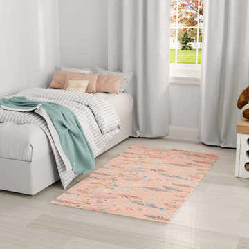 Kids bedroom with a Nourison Imagination Pink Multicolor rug, bed, and white curtains.