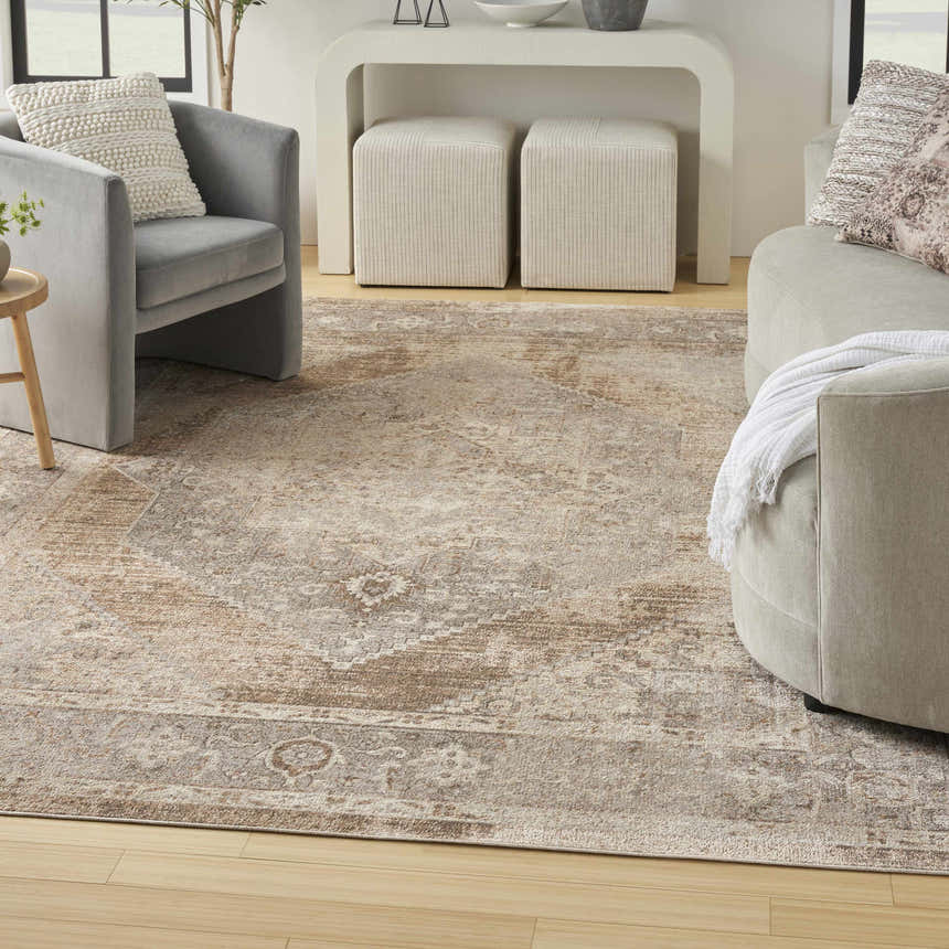 Living room scene with a beige vintage Nourison Astra area rug, gray chairs, and neutral decor.
