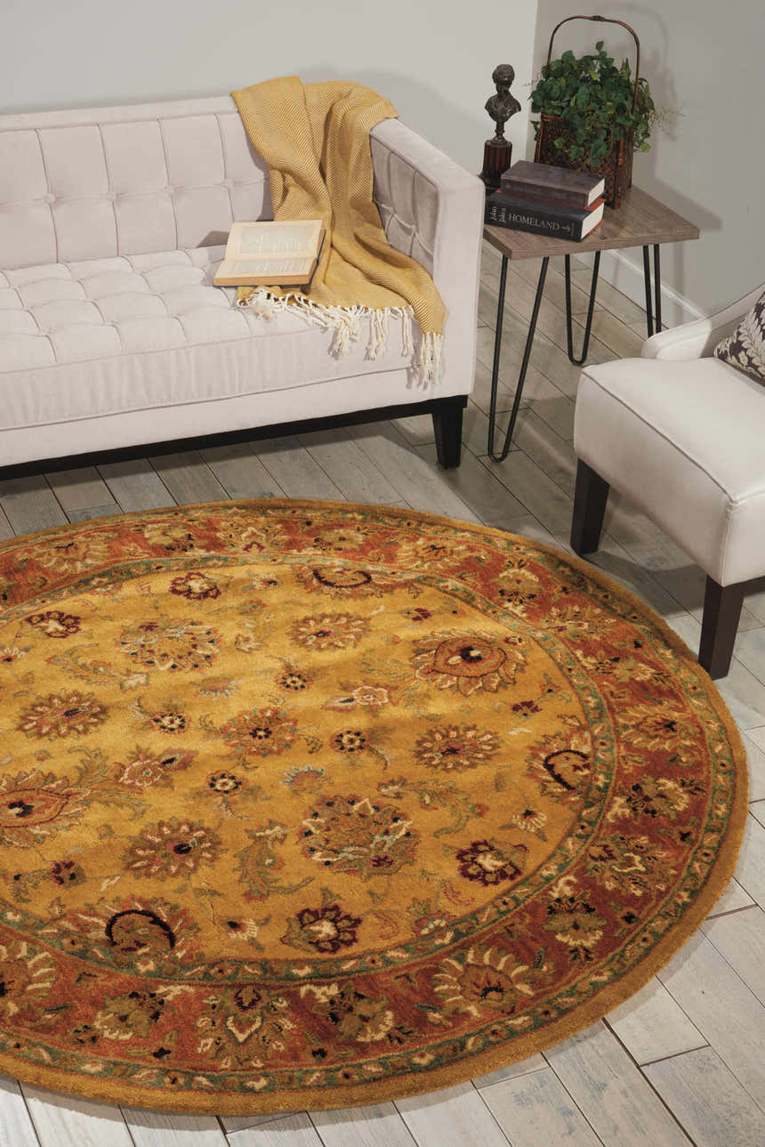 Living room scene with a round Nourison Jaipur Gold rug, cream sofa, and wood floors.