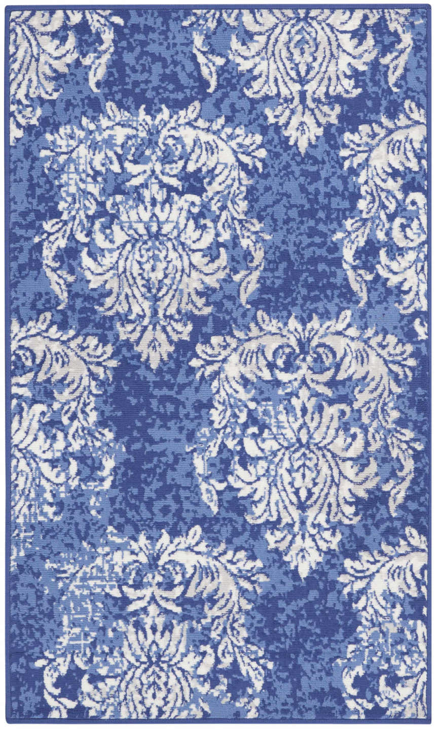 Close-up of the Nourison Whimsicle Navy Ivory rug. Features a farmhouse floral damask pattern in shades of blue and ivory.