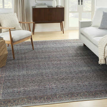 Living room with a Nourison Grand s Emerald Vintage rug, light gray sofa, wood chair, and mid-century modern cabinet.
