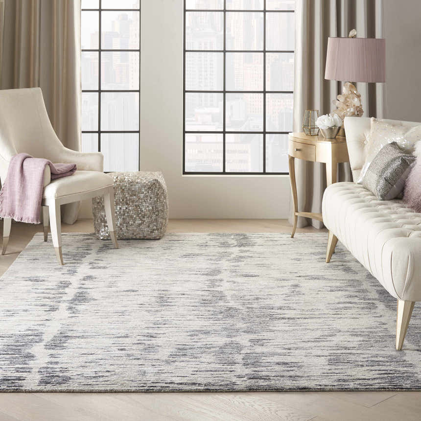 Living room scene with a cream sofa and Nourison OCEAN Cream Charcoal rug.
