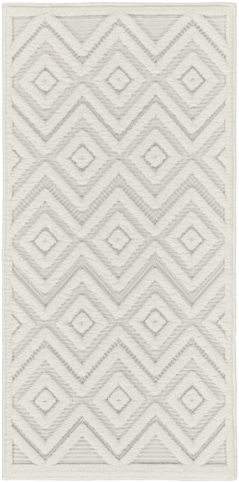 Close-up of Nourison Versatile Ivory White rug with geometric diamond and chevron pattern. Mid-century modern style.