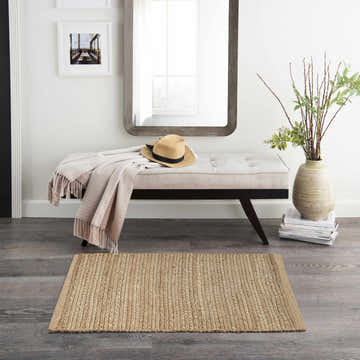 Entryway with bench, mirror, and Nourison Natural Jute rug. Farmhouse style with neutral colors.