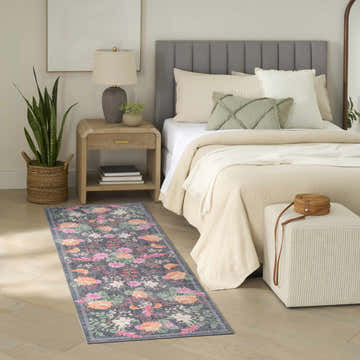 Farmhouse bedroom with Nourison Botanical Charcoal rug, wood floors, and neutral bedding.