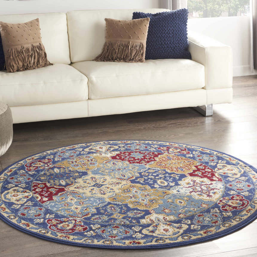 Living room with a white couch and round Nourison Grafix Multicolor Bohemian Area Rug in blue, red, and gold.