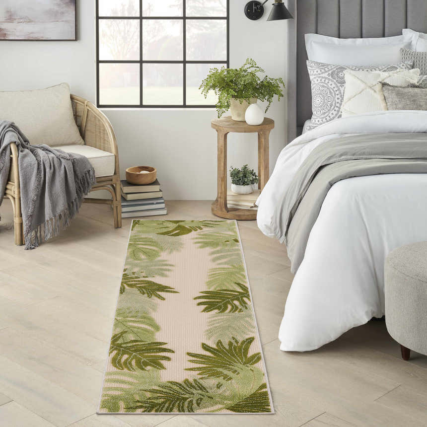 Bedroom scene with a Nourison Aloha Ivory Green runner rug, light wood floors, and neutral furniture.