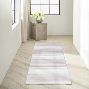 Hallway scene with Calvin Klein Launder Ivory rug runner. Modern, light wood floors, concrete side table, and white tulips.