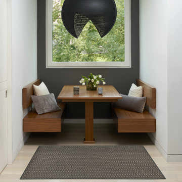 Modern dining nook with wood benches and Horizon Charcoal Area Rug.