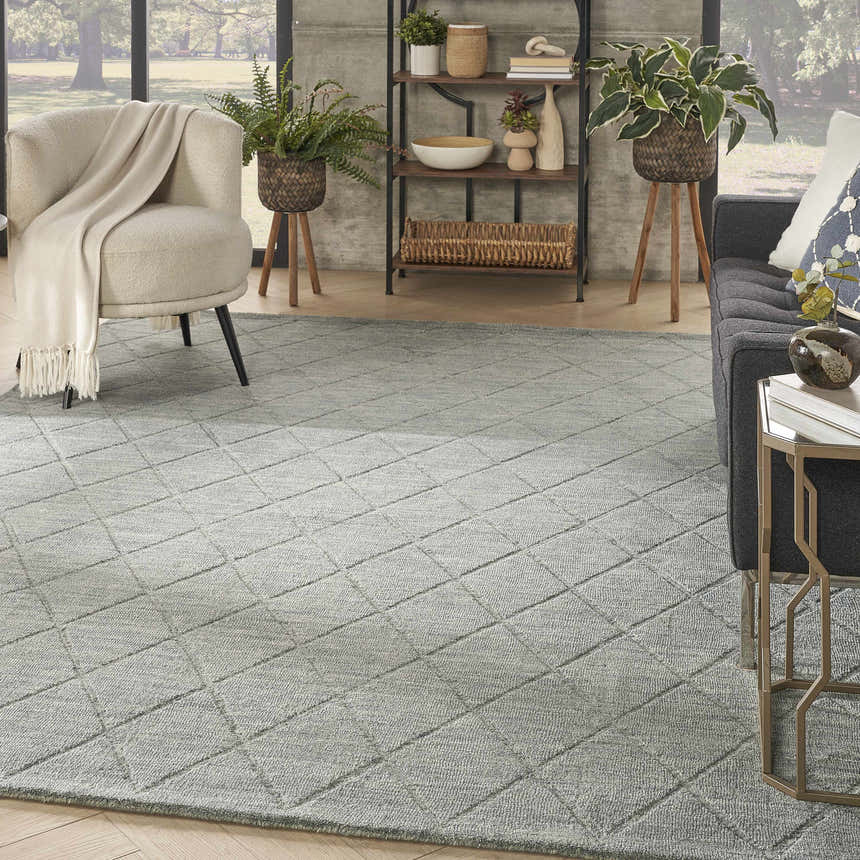 Living room scene with a Nourison Wool Haven Blue rug, gray sofa, and neutral armchair. The rug has a diamond pattern.