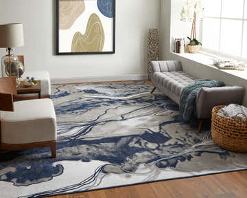 Living room scene with Feizy Gaspar blue/gray rug, white chairs, gray bench, and wood floors. Roomscene-Rectangle