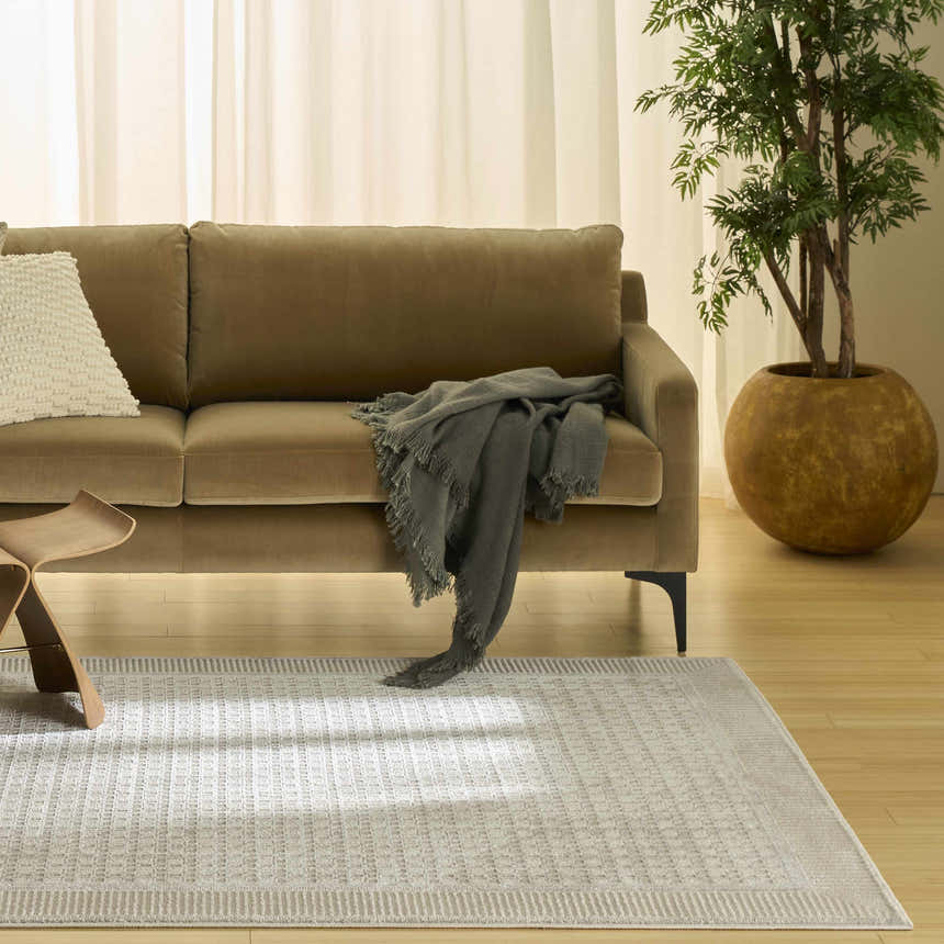 Living room scene with a beige sofa and Nourison Nordic Beige Modern Area Rug.