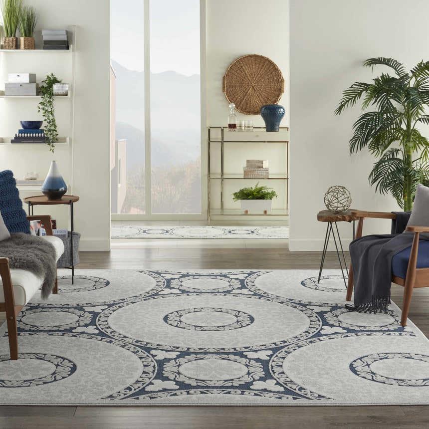 Living room scene with a Nourison Key Largo Blue Contemporary Area Rug, chairs, and modern decor.