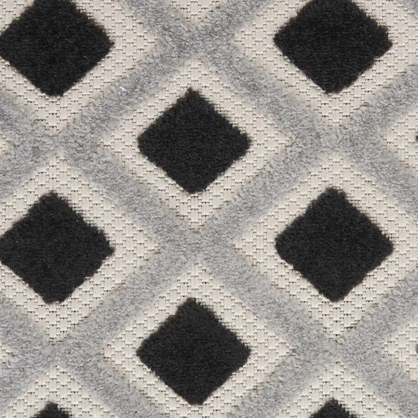 Close-up of the Nourison Aloha Black White Modern Area Rug featuring a geometric diamond pattern.