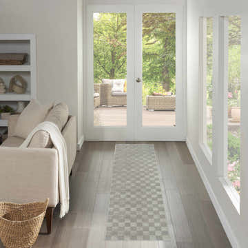 Living room scene with a Nourison Serenity Home Grey runner rug leading to a bright patio. Neutral tones, modern style.