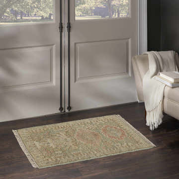 Entryway with Nourison Heritage Vine Light Blue rug on dark wood floor. Beige chair with throw and books.