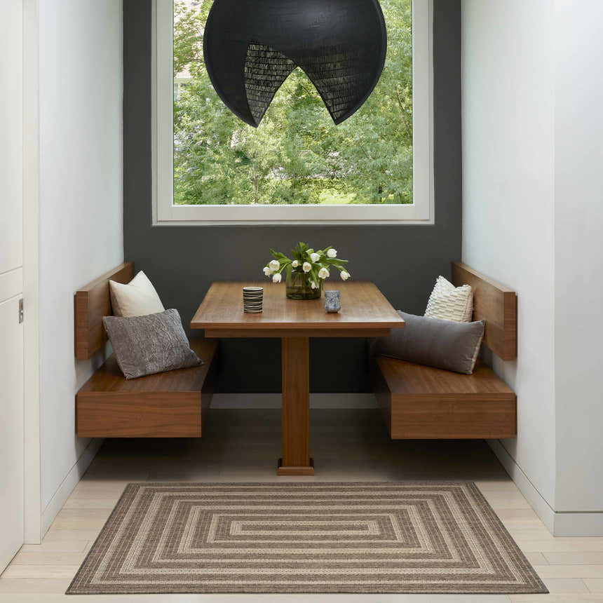 Breakfast nook with wood benches and Tulum Brown Outdoor Area Rug.