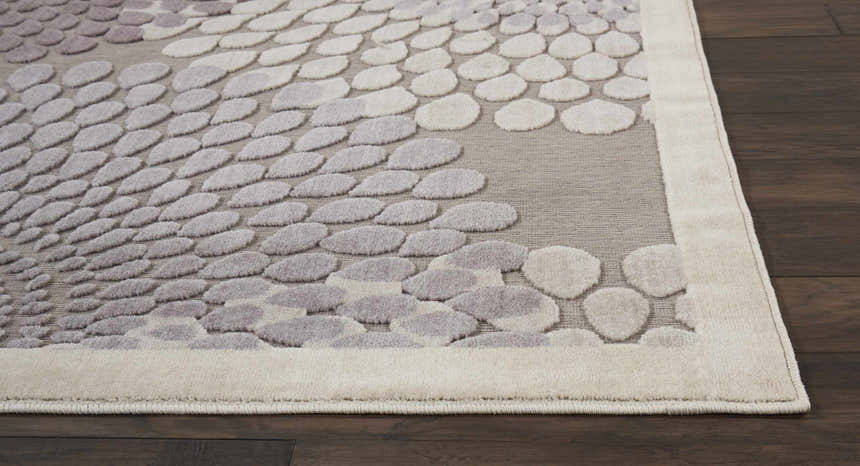 Close-up of the grey Nourison Graphic Illusions rug, featuring a raised pebble pattern and a soft, neutral color palette.