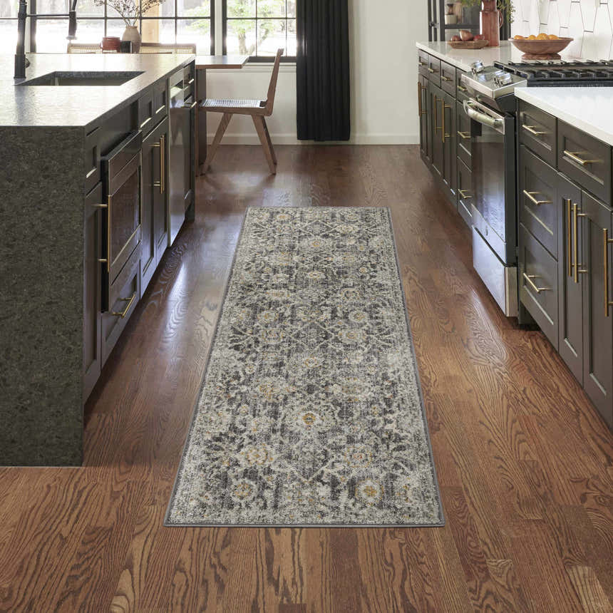 Kitchen scene with Nourison Oushak Home Charcoal Vintage Indoor Area Rug runner on hardwood floors between dark cabinets.