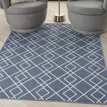 Living room scene with gray swivel chairs and Nourison Modern Lines Denim rug with geometric pattern.