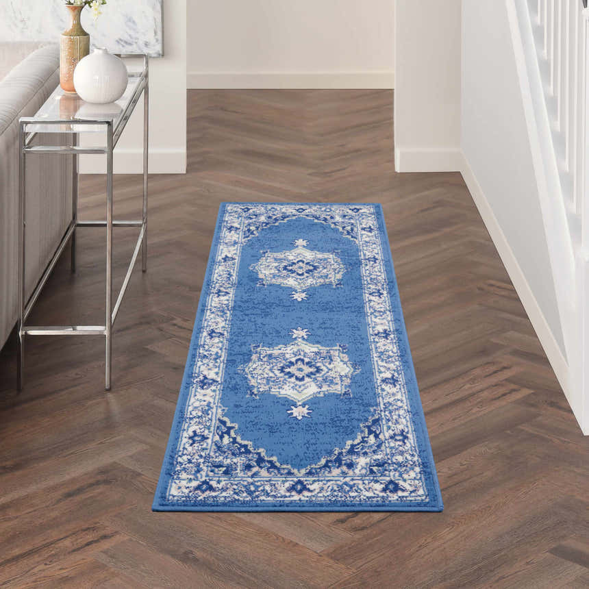 Hallway scene with a Nourison Whimsicle Navy Farmhouse Indoor Area Rug runner on dark wood floors. Modern decor.