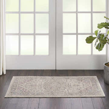 Entryway with Nourison Tranquil Ivory Pink Vintage rug on dark wood floor, white doors, and potted plant.