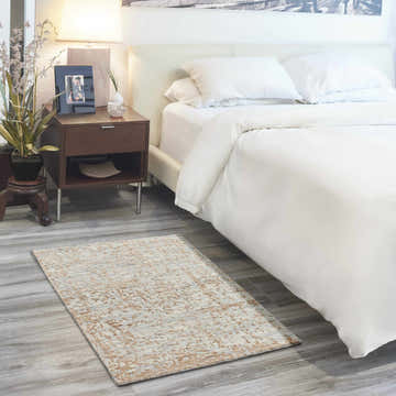 Bedroom scene with a Nourison Luna Blue Mocha rug, white bedding, and a dark wood nightstand.