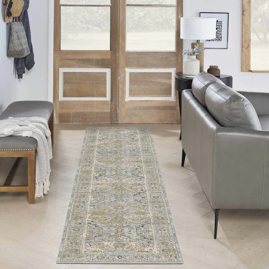 Entryway with a Nourison Lynx Light Blue Vintage rug, grey bench, wood doors, and a modern grey sofa.