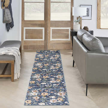 Entryway with Nourison Navy Multicolor Vintage rug, wood floors, gray bench and sofa, and rustic wood doors.