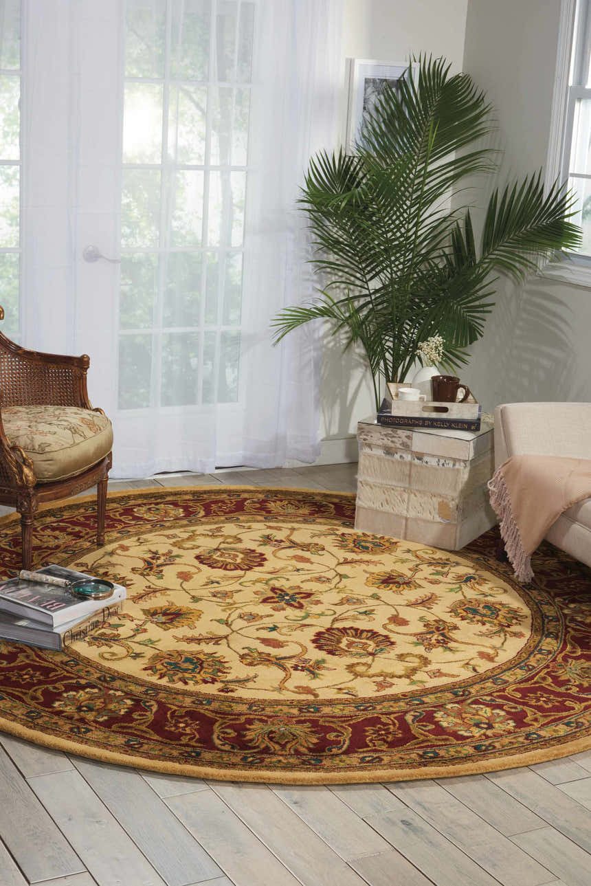 Sunlit room with round Nourison Jaipur Light Gold rug, floral pattern, rattan chair, and neutral furniture.