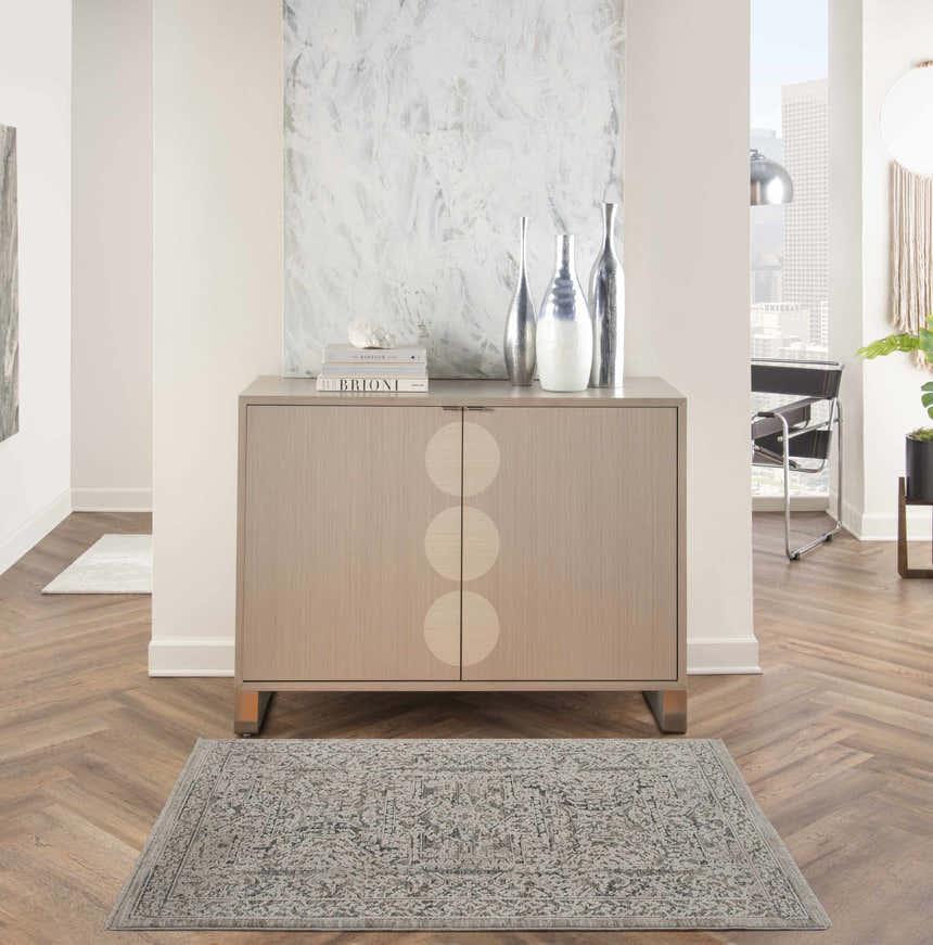 Living room scene with a Nourison Lynx Ivory Grey Blue Vintage rug, wood floors, and modern decor.