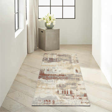 Hallway with Calvin Klein CK005 Enchanting Grey Rust rug, concrete side table, white tulips, and light wood floors.