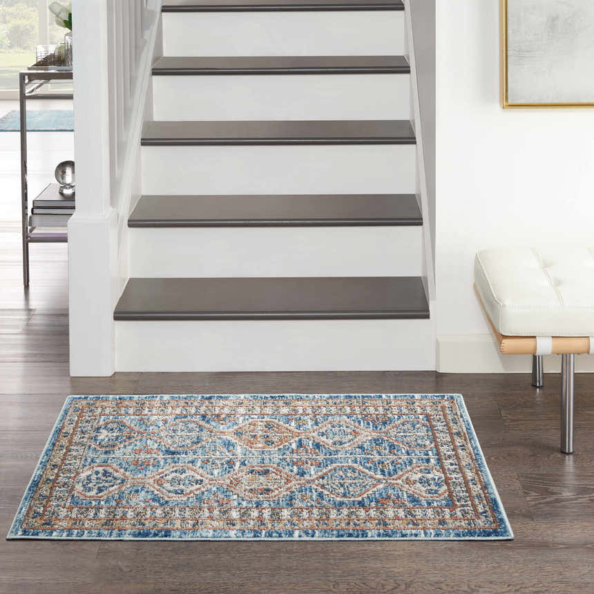 Entryway with Nourison Quarry Blue Multicolor rug, white stairs, and a modern white bench.