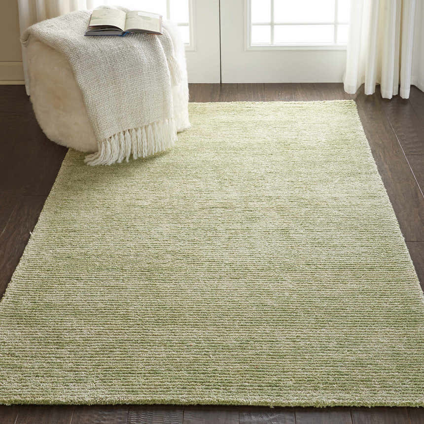 Modern living room scene with a citron Nourison Weston area rug and white ottoman.