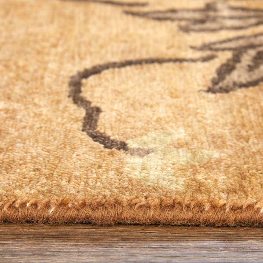Close-up of the hand-knotted Feizy Cordonnet rug. Brown and orange wool with a floral botanical pattern and detailed edge. Pile