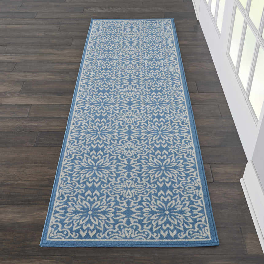 Hallway scene with Nourison Jubilant Ivory Blue rug runner on dark wood floor, next to white trim and window.