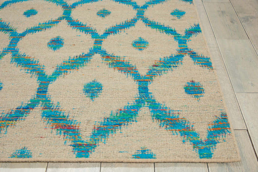 Close-up of the Nourison Spectrum Beige Turquoise rug, featuring a geometric trellis pattern and textured weave.