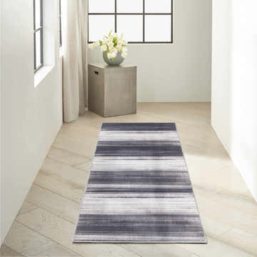Hallway scene with a Calvin Klein Launder Ivory Black rug, light wood floors, and modern decor.