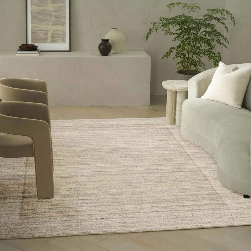 Farmhouse living room with Calvin Klein CK082 Ridge rug, beige chairs, curved sofa, and neutral decor.
