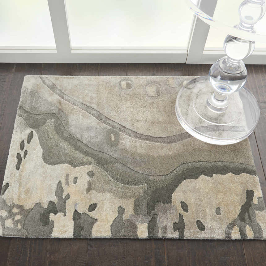 Close-up of Nourison Prismatic Silver Cloud rug with abstract pattern and soft texture on dark wood floor.
