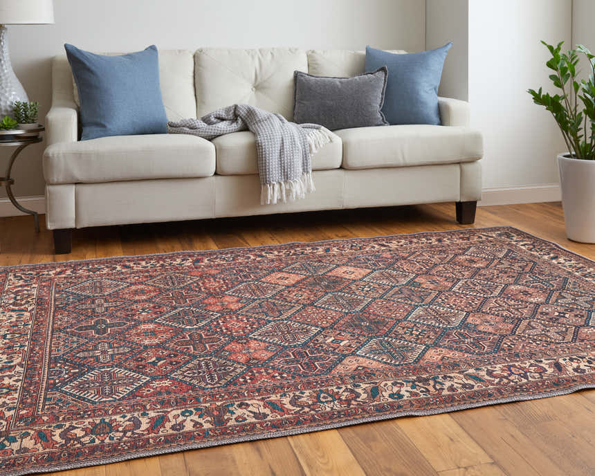 Living room scene with a Feizy Rawlins brown, red, and ivory rug, sofa, pillows, and plant. Roomscene-Rectangle