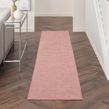 Hallway scene with a Nourison Positano Rainbow Runner Rug on dark wood floors, light walls, and a glass console table.