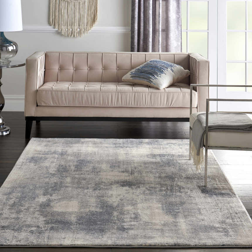 Living room scene with a Nourison Rustic Textures Blue Ivory rug, blush sofa, and modern decor.