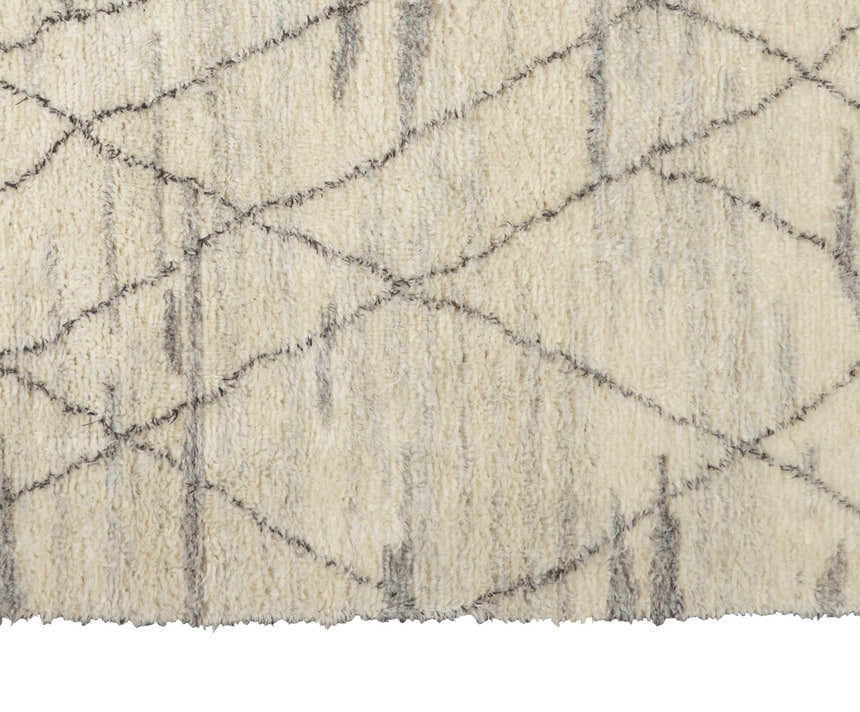 Close-up of the Calvin Klein San Antonio ivory shag rug. Features a gray Moroccan diamond pattern and wool texture.