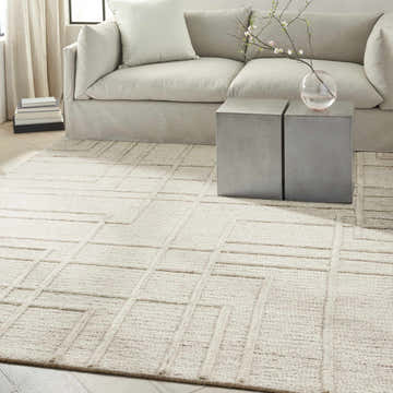 Living room scene with a sand colored Calvin Klein CK045 Impressions wool rug and modern furniture.