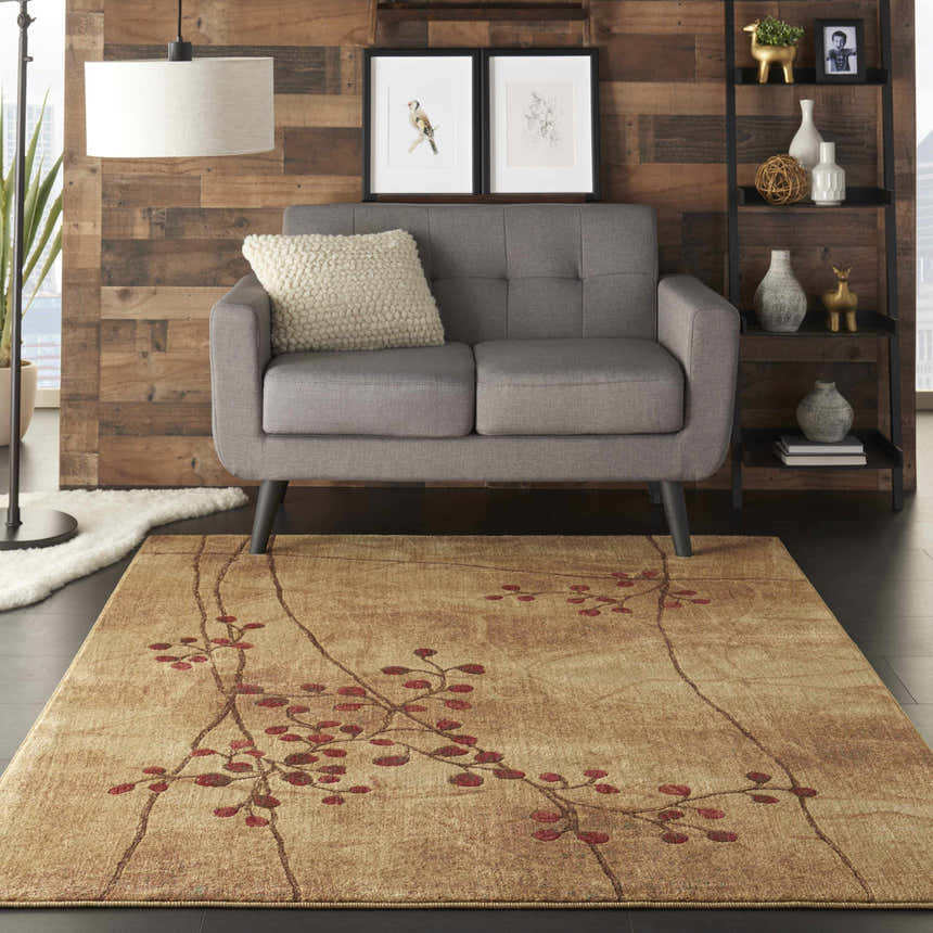 Living room scene with a grey loveseat on a Nourison Somerset Latte rug with branch and leaf pattern.