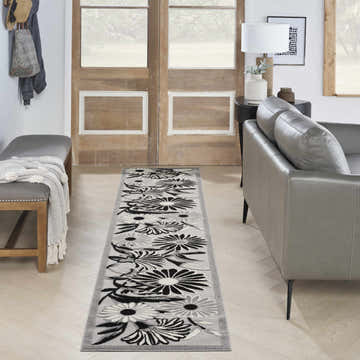 Entryway with gray bench and Nourison Aloha Black White Outdoor Area Rug runner featuring a floral pattern.