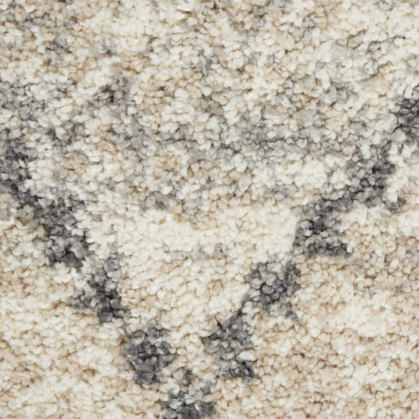 Close-up of the Nourison Oslo Shag rug. Ivory, gray, and chestnut tones create a soft, textured shag design.
