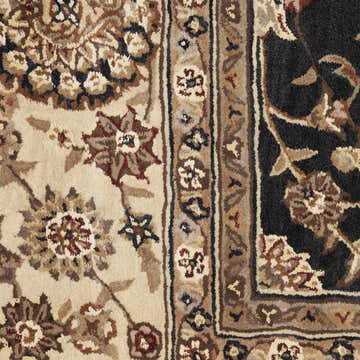 Close-up of Nourison 2000 Midnight rug showing floral patterns in beige, brown, and black. Handmade wool rug texture.