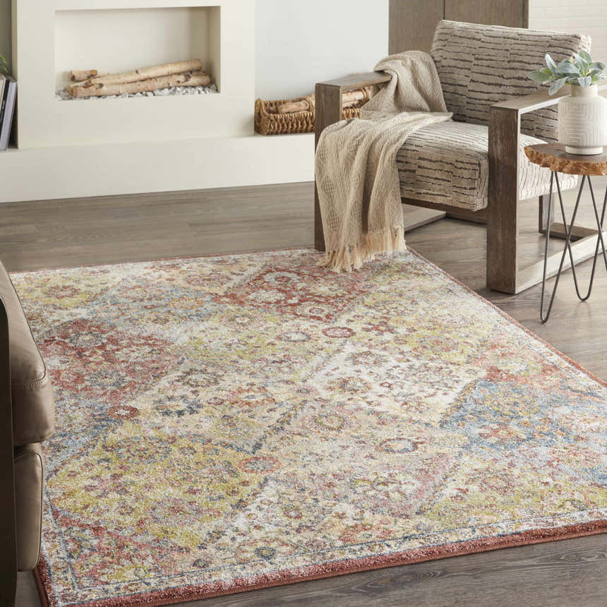Living room scene with a Nourison Soraya Terracotta Multicolor rug, chair with throw, fireplace, and wood floors.